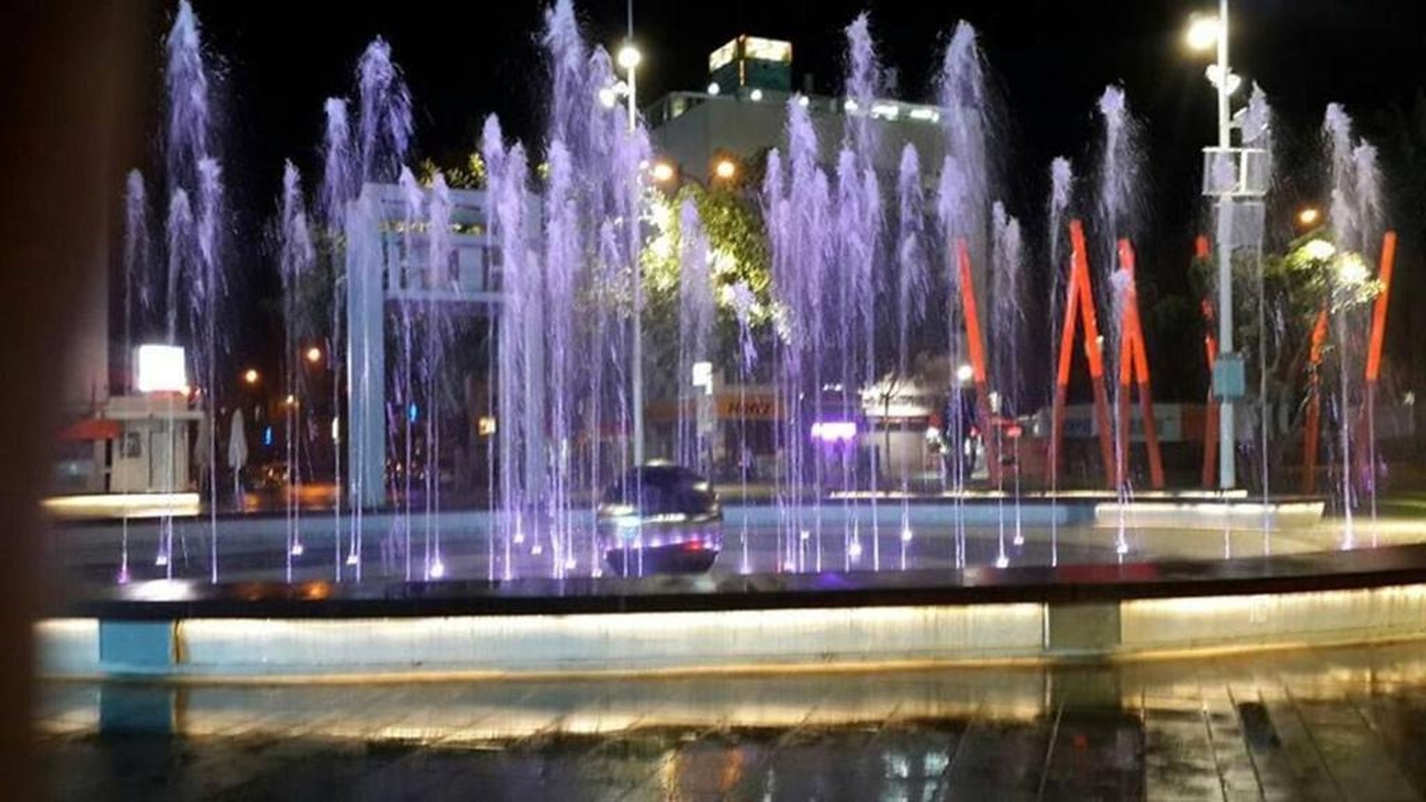 Fontaines lumineuses violettes de la place Ha'Atzmaout la nuit